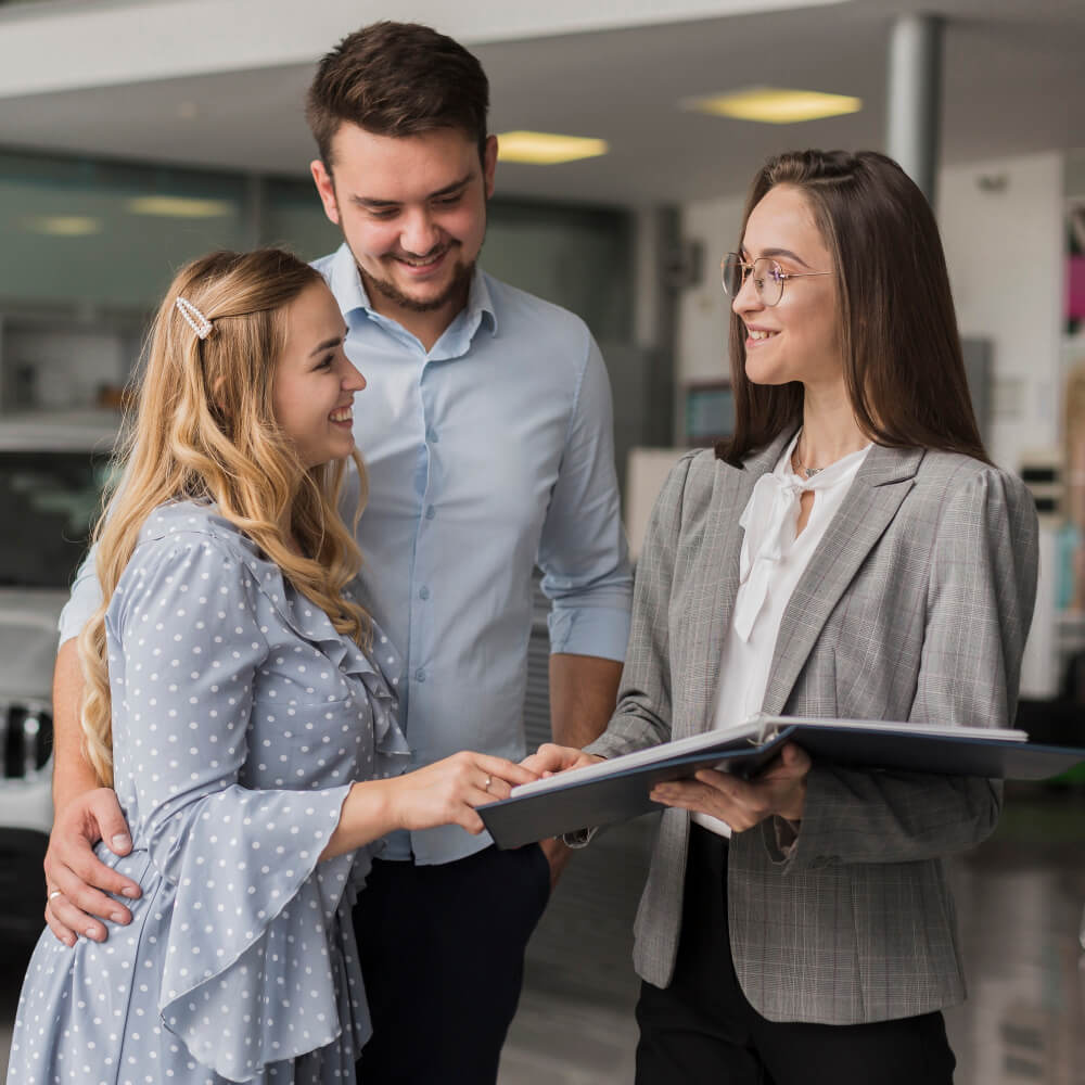 Happy couple talking with a car dealer