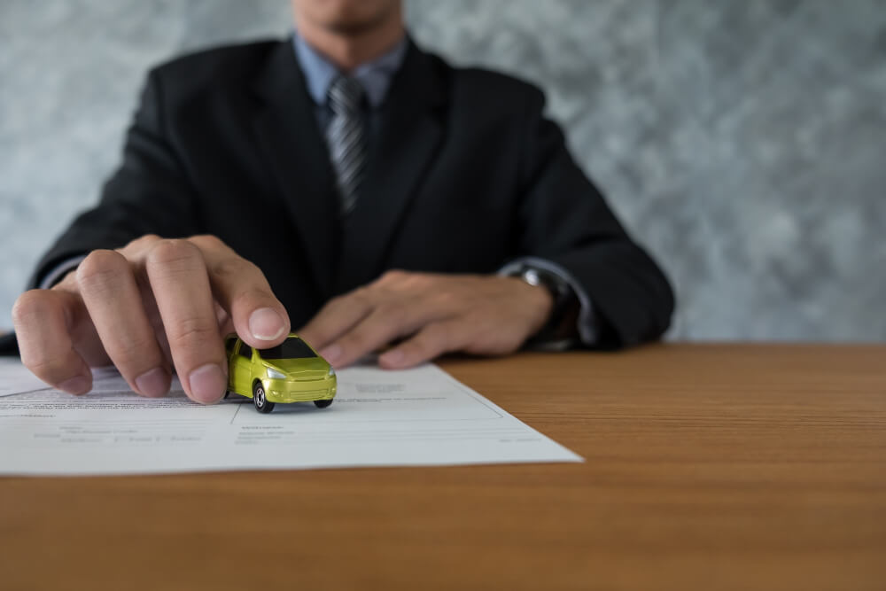 Transportation and ownership concept - customer and salesman with car key
