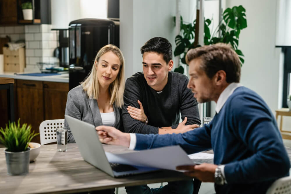 Young couple and real estate agent using laptop Young couple and real estate agent using laptop
